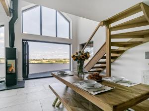 a dining room with a wooden table and stairs at The Old Coach Garage in Gerrans +11 photos