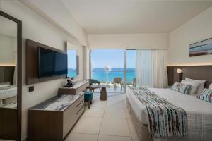 ein Hotelzimmer mit Bett und Flachbildfernseher in der Unterkunft Pernera Beach Hotel in Protaras