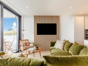 a living room with a green couch and a tv at Chi An Mor in Charlestown +21 photos