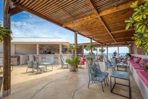 a patio with chairs and tables with the ocean in the background at Armeno Resort in Marathias