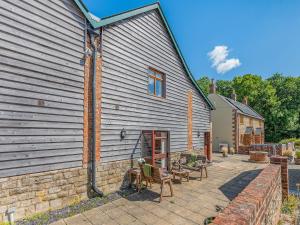 a patio with chairs and a building at Granary - Uk49910 in Blandford Forum