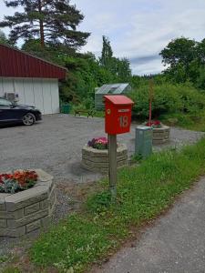 a red mailbox in front of a parking lot at Apartment by the park in Imatra