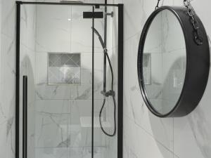 a shower with a round mirror in a bathroom at The Bunker in Otterburn