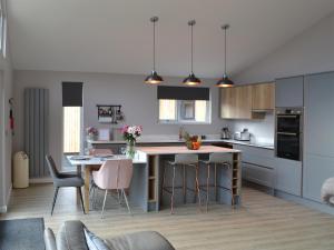 a kitchen with a large island with bar stools at The Bunker in Otterburn