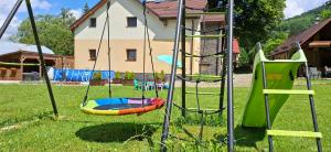a playground with a slide and a swing set at Vila Pohoda Javorníky s rozľahlým pozemkom in Makov