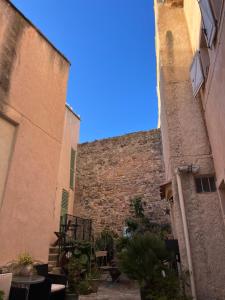 an alley between two buildings with a stone wall at Apparemment Cocooning Ceyreste in Ceyreste