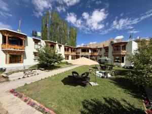 a courtyard of a building with a park with benches at Mandalchan hotel in Leh
