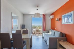 a living room with a couch and a table at Résidence Odalys Terra Gaia in Sète