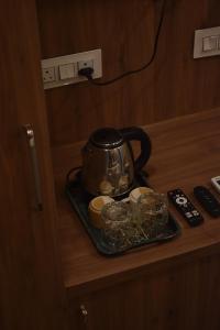 a tea kettle and dishes on a tray on a counter at 4 Seasons Residency in Katra