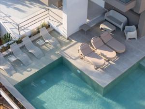 an overhead view of a swimming pool with chairs and a table at Solianna Rethymno Suites in Rethymno