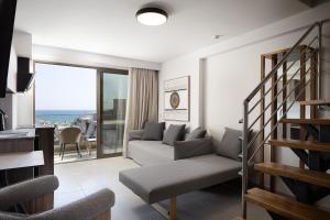 a living room with a couch and a staircase at Solianna Rethymno Suites in Rethymno