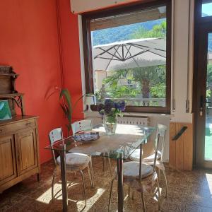 a dining room with a glass table and chairs at Cà dl'Ernesto in Varallo