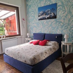 a bedroom with a blue bed with red pillows on it at Cà dl'Ernesto in Varallo