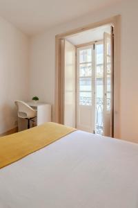 a bedroom with a bed and a sliding glass door at LOVELY Central Apartment 3Bdr by Vinum Apartment 1890 in Coimbra