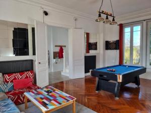 a living room with a pool table and a couch at La Casa des Frangins in Saint-Romain-de-Colbosc +5 photos