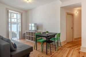 a living room with a table and green chairs at LOVELY Central Apartment 3Bdr by Vinum Apartment 1890 in Coimbra