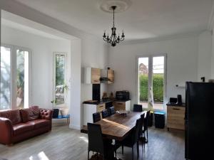 a living room with a table and a couch at La Casa des Frangins in Saint-Romain-de-Colbosc