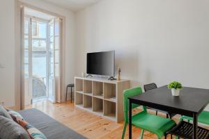 a living room with a table and a tv at LOVELY Central Apartment 3Bdr by Vinum Apartment 1890 in Coimbra