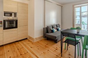 a kitchen and living room with a table and a couch at LOVELY Central Apartment 3Bdr by Vinum Apartment 1890 in Coimbra +34 photos