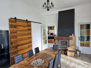 a dining room with a table and a fireplace at La Casa des Frangins in Saint-Romain-de-Colbosc