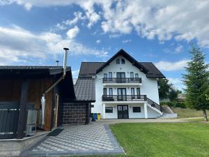 a white house with a black roof at Cacica Holiday in Cacica