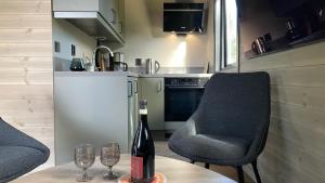 a bottle of wine sitting on a table with two glasses at Hjertero - Hide Away Suite in Sortland +24 photos