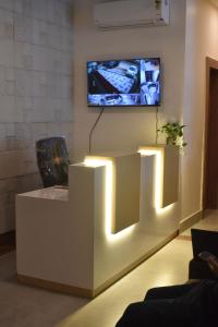 a living room with a tv on a wall with lights at 4 Seasons Residency in Katra +12 photos
