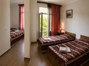 a hotel room with two beds and a window at Zanger Hotel in Goris