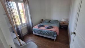 a bedroom with a bed and a desk and a window at Les Pâquerettes in Dinan +26 photos