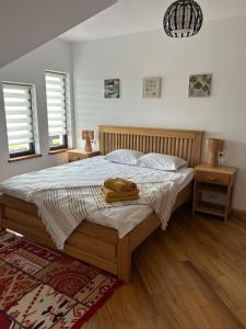 a bedroom with a bed with two night stands and two windows at Cacica Holiday in Cacica