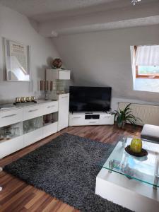 a living room with a flat screen tv and a table at Ferienwohnung mit Elbwiesenblick in Lutherstadt Wittenberg