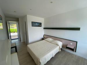 a bedroom with a bed in a room at BELLE VUE MER STUDIO PISCINE in Trévou-Tréguignec +14 photos