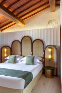 a bedroom with a large white bed with green pillows at Chapter Chianti, a Member of Design Hotels in Cavriglia +40 photos