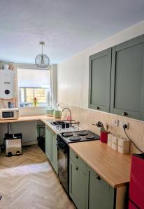 a kitchen with green cabinets and a stove top oven at 7 dodds lane alnwick in Alnwick