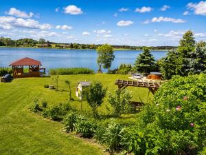 ein Garten mit einem Pavillon und einem See in der Unterkunft Sentane in Swiętajno