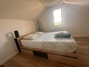 a small bedroom with a bed with a window at Pure comfort in Entrelacs