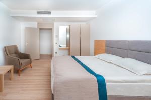 a bedroom with a large bed and a chair at Riversea Suite & Hotel in Lara