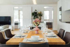 a table with glasses and a vase with flowers on it at Bodensee Bergblick Nest by Stadtlandnest in Lochau