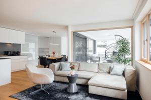 a living room with a couch and a table at Bodensee Bergblick Nest by Stadtlandnest in Lochau