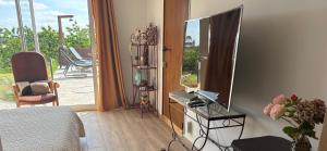 a room with a bed and a television and a balcony at Les vergers d'Anjoy in Montesquieu