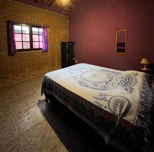 a bedroom with a large bed in a room at Tahoma Chalé Rustico Lila Prumirim in Ubatuba