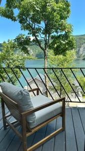 a chair sitting on top of a deck with a tree at Serenity in Eşelniţa