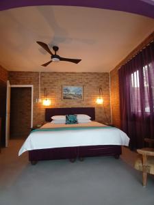 a bedroom with a bed with a ceiling fan at The Laughing Mermaid in Coffee Bay +12 photos