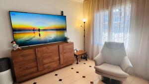 a living room with a flat screen tv on a dresser at Apartment-House La Mata Torrevieja in Torrevieja