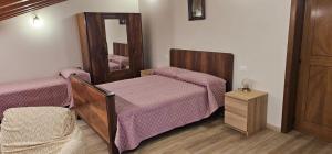 a small room with two beds and a mirror at Casa Delia in Piazzano