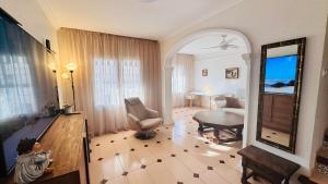 a woman sitting in a living room with a mirror at Apartment-House La Mata Torrevieja in Torrevieja +35 photos