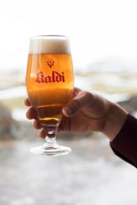 a person holding up a glass of beer at Vogafjós Farm Resort in Myvatn