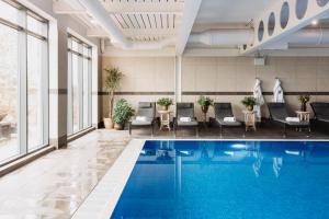 a hotel lobby with a pool and chairs at Marine North Berwick in North Berwick