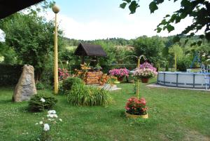 a garden with flowers and a gazebo at Agroturystyka nad Sanem in Dydnia