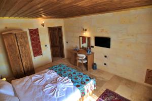 a bedroom with a bed and a desk at Süleyman Cappadocia - Hot Air Balloon View in Göreme
